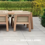 Close-up van teakhouten eettafel en stoelen op grote grijze Piet Boon Outdoor tegels