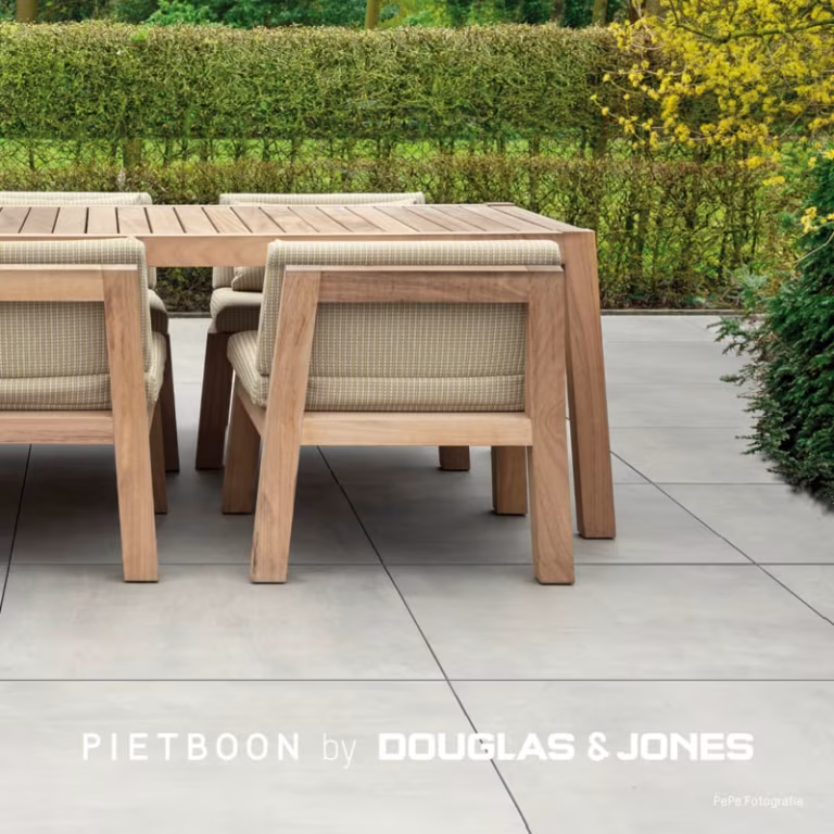 Close-up van teakhouten eettafel en stoelen op grote grijze Piet Boon Outdoor tegels