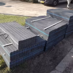 Pallets met zwart antraciet opsluitbanden en blauwe spanbanden op gras