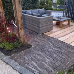 Tuin met loungebank en houten vlonder naast pad van Nostalgie wasserstrich klinkers