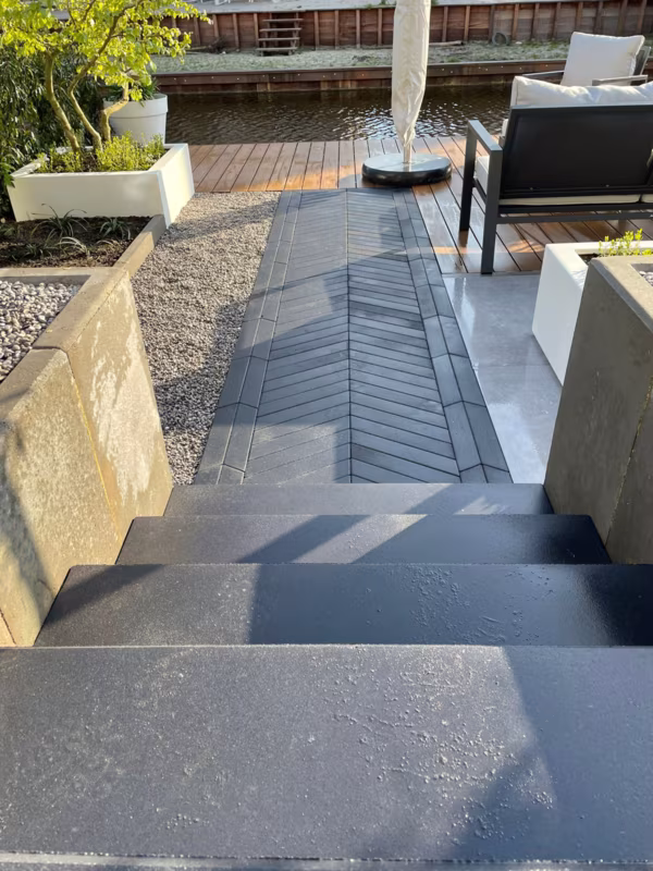 Visgraatpad Romano Punto langs trap naar terras met loungestoelen aan het water