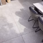 Terras met GeoCeramica Palanta Plus Smoke tegels, houten tafel en rieten stoelen