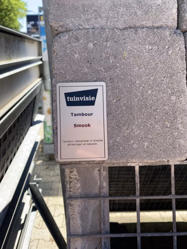 Tambour Smook steen met Tuinvisie artikellabel op showroomstaal, close-up