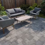 Loungeset met houten salontafel op terras van Tambour Smook bestrating