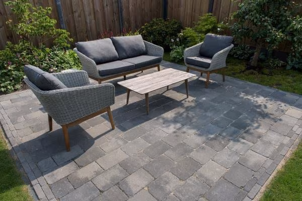 Loungeset met houten salontafel op terras van Tambour Smook bestrating