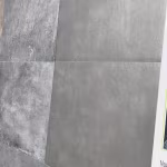 Showroomstaal Kera Full Body Leuven naast gemarmerde blauwgrijze tegel, close-up met label