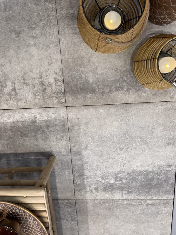Bovenaanzicht grijze Soft Comfort Grezzo tegels met rieten lantaarns op terras