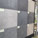 Showroomwand met grijze en antraciete keramische tegels met groene labels