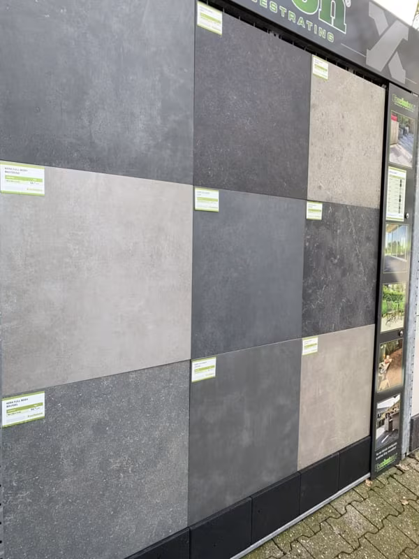 Showroomwand met grijze en antraciete keramische tegels met groene labels