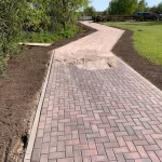 Bochtig pad van rood-zwarte Tremico BKK klinkers 7 cm met opsluitband en gras