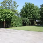 Grote tuin met gazon, bomen en terras van Kera Full Body 60x60x3 Bastogne