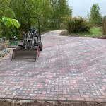 Oprit van rood-zwarte Tremico BKK klinkers 7 cm in aanleg met minigraver