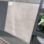Showroomstaal Kera Full Body Bastogne in rek naast donkere tegels met groen label
