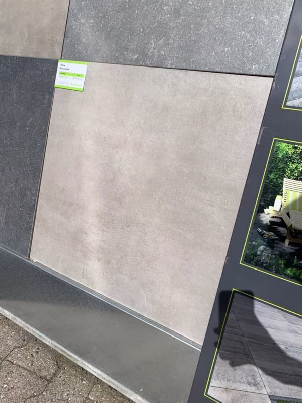 Showroomstaal Kera Full Body Bastogne in rek naast donkere tegels met groen label