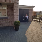 Opritje van BSS betonklinkers 8 cm in visgraat voor garage naast bakstenen woning