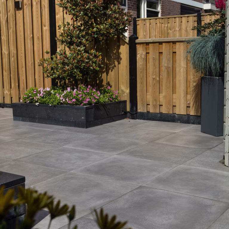 GeoCeramica Fumato Mezzo terras met houten schutting, plantenbak met roze bloemen en siergras