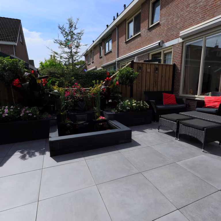Achtertuin van rijtjeshuis met GeoCeramica Fumato Mezzo terras, vijver en loungemeubels