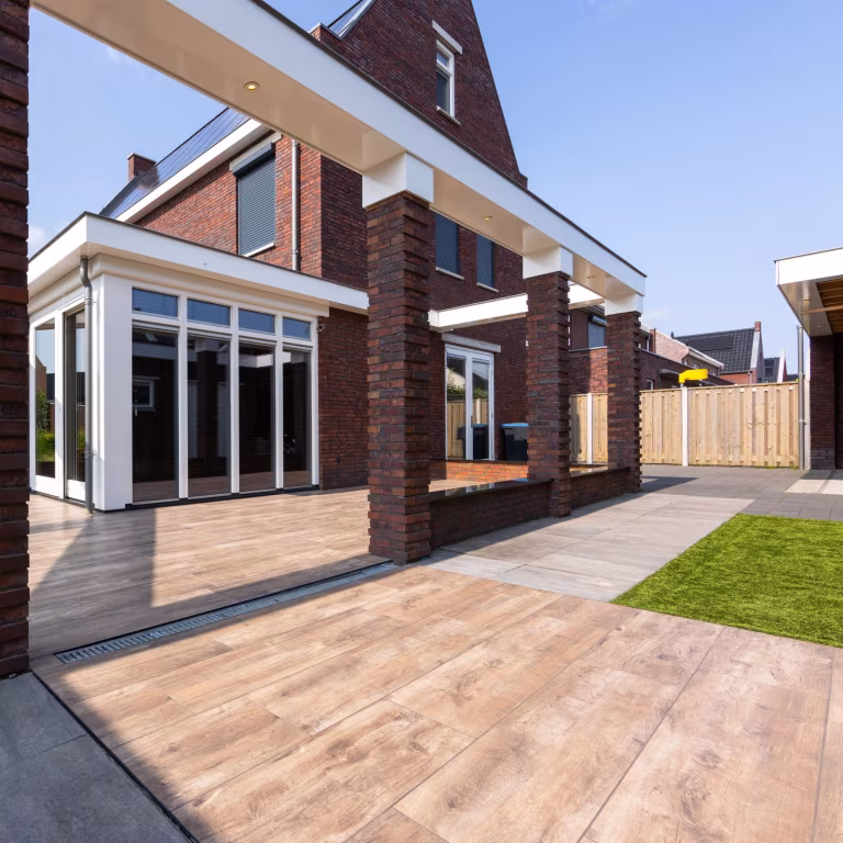 Bakstenen pilaren, witte pui en afvoergoot langs Timber Noce houtlooktegels