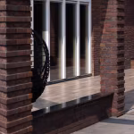 Bakstenen pilaren en pui met Timber Noce houtlooktegels op verhoogd terras