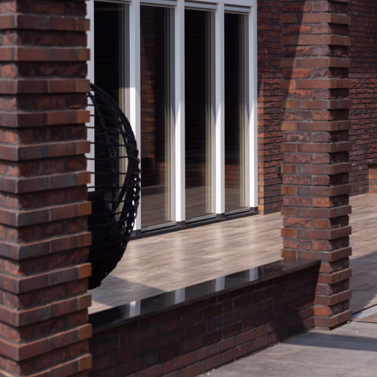 Bakstenen pilaren en pui met Timber Noce houtlooktegels op verhoogd terras