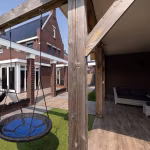 Houten paal met nestschommel en loungebank bij Timber Noce vloer in overdekt gedeelte