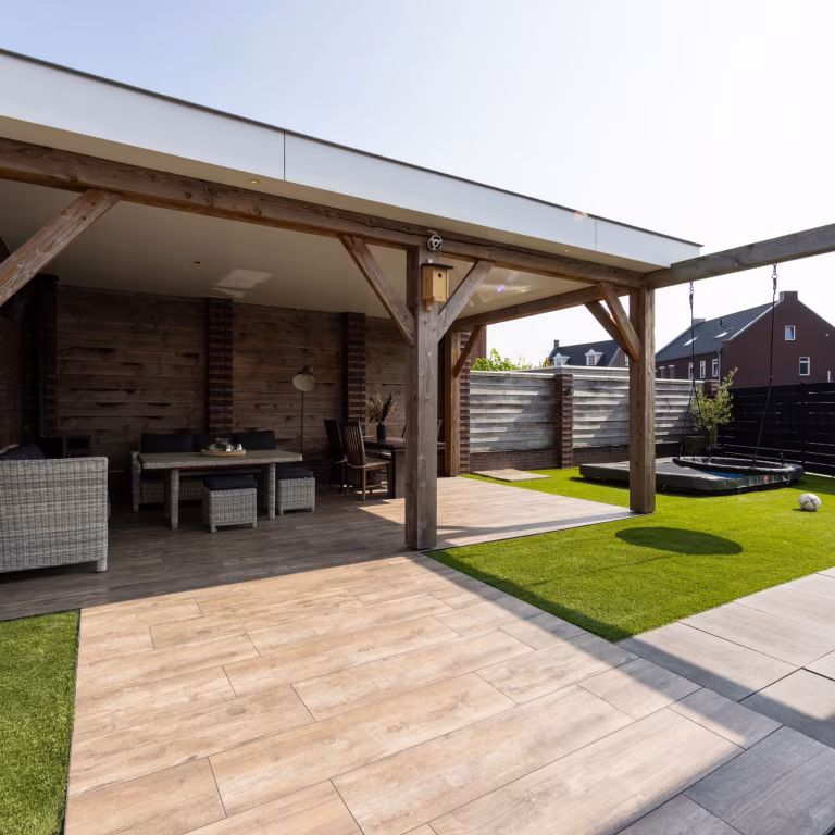 Overdekt terras met tuinset en Timber Noce tegels naast kunstgras en antraciete tegels