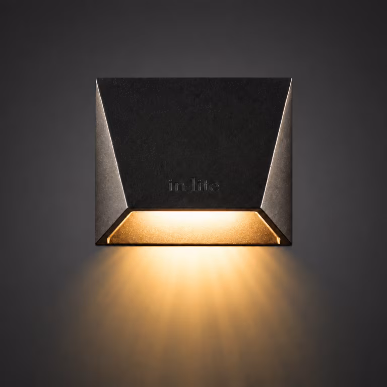 In Lite Mini Wedge wandlamp met warm licht naar beneden op donkere achtergrond