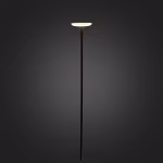 In Lite Sway Tube staande lamp brandt met warm licht op donkere achtergrond