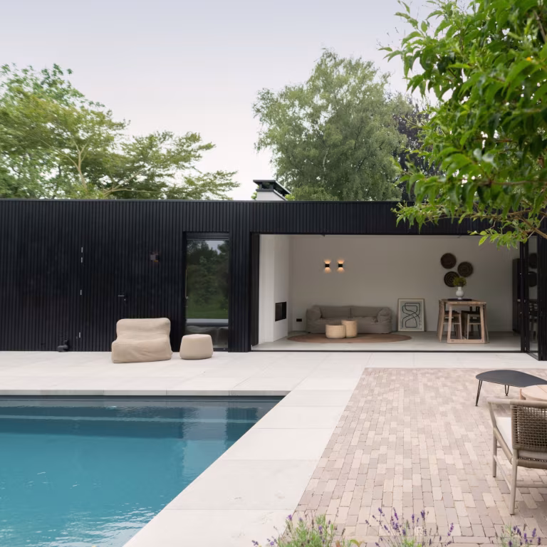 Zwembad met zwart poolhouse en terras van Lotis klinkers met lichte tegelrand