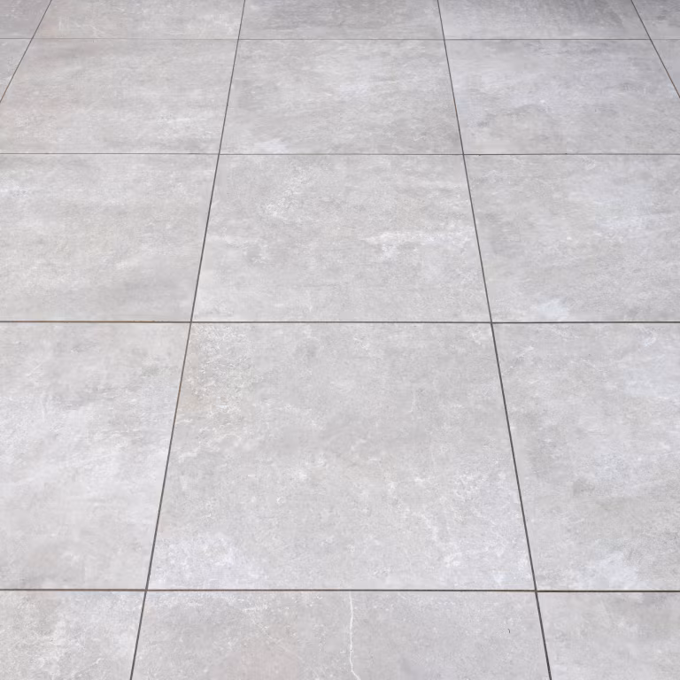Lichtgrijze GeoCeramica tegels 60x60 met smalle voegen, schuin gezien in close-up