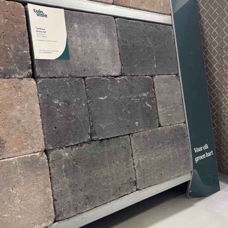 Schuin showroomstaal Tambour Antraciet getrommelde stenen met label en groene Tuinvisie banner