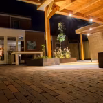 Avondfoto van verlicht overdekt terras met Tambour Brons waalformaat in verband