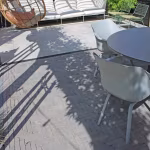 Schaduwspel op Tambour Mangaan waalformaat terras met grijze stoelen en ronde tafel