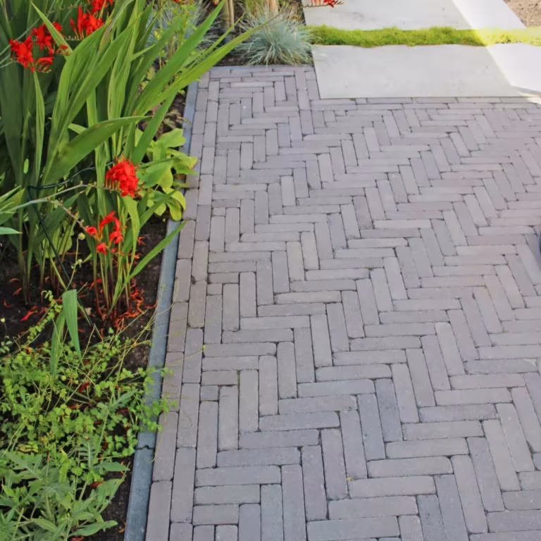 Pad van Tambour Mangaan waalformaat in visgraatverband langs border met rode bloemen