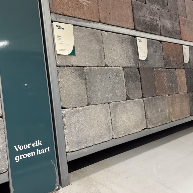 Showroomwand met Tuinvisie stenen in grijze en bruine tinten, schuin gezien met labels