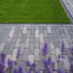Close-up van Tambour Smook klinkers in strak verband met gras en paarse lavendel