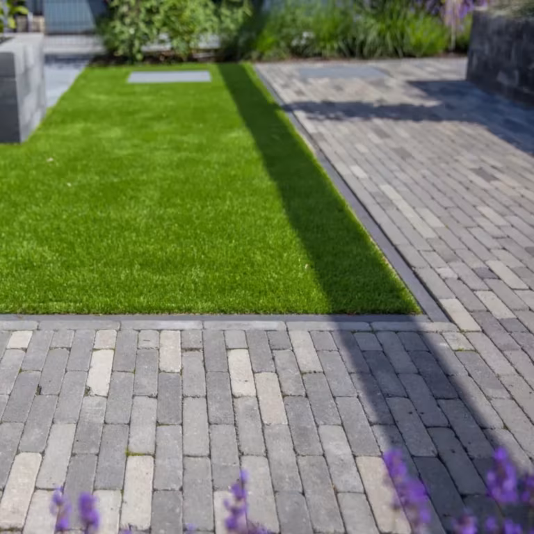 Kunstgrasstrook tussen Tambour Smook klinkerpaden met lavendel op de voorgrond