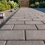Antraciet betonklinkers 8 cm in pad met zwarte opsluitband, tuinspots en hortensia's