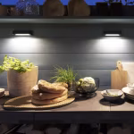 Wedge Slim wandlampen boven buitenkeuken met brood en houtopslag in de avond