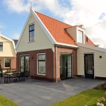 Tuin met Soft Comfort Nero tegelterras voor klassieke woning met rood pannendak