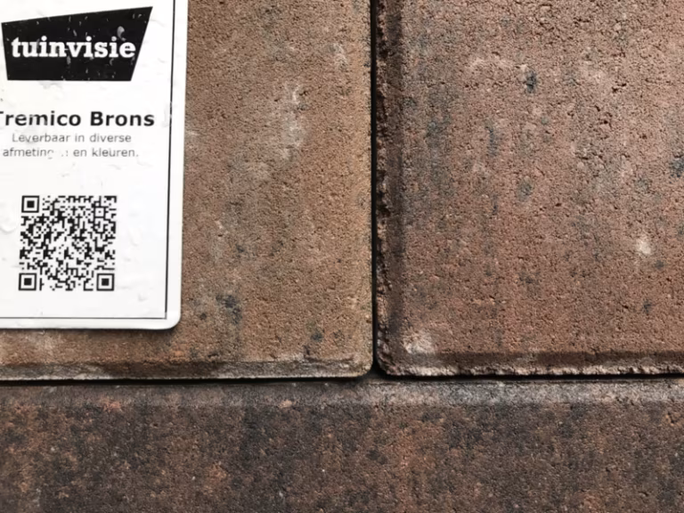 Showroomstaal Tremico Brons met label en QR-code naast klinkers in bruine tinten