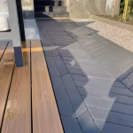 Visgraatbestrating Romano Punto naast houten vlonder met trap op de achtergrond