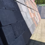 Showroomwand met Tambour Antraciet en rode stenen in zon en schaduw, buiten