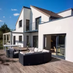 Moderne witte woning met loungeset op terras van Timber Noce houtlooktegels