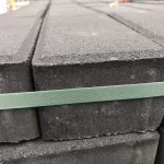 Zijkant van gestapelde antraciet betonklinkers 8 cm met groene spanband