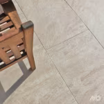 Houten tuinstoel op beige Ceramaxx Andes Gold tegels, close-up met voegen