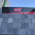 Tuinvisie showroomstaal met grijze Tambour Smook stenen tegen blauwe lucht