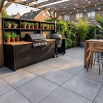 Buitenkeuken met barbecue en kruidenplanten op grijs terras onder pergola met lichtsnoer