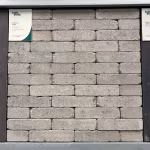 Showroomstaal Tambour Taupe waalformaat frontaal tussen donkere panelen met label