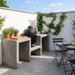 Buitenkeuken met kamado en bistrotafel op Kera Full Body Bari terras voor witte muur